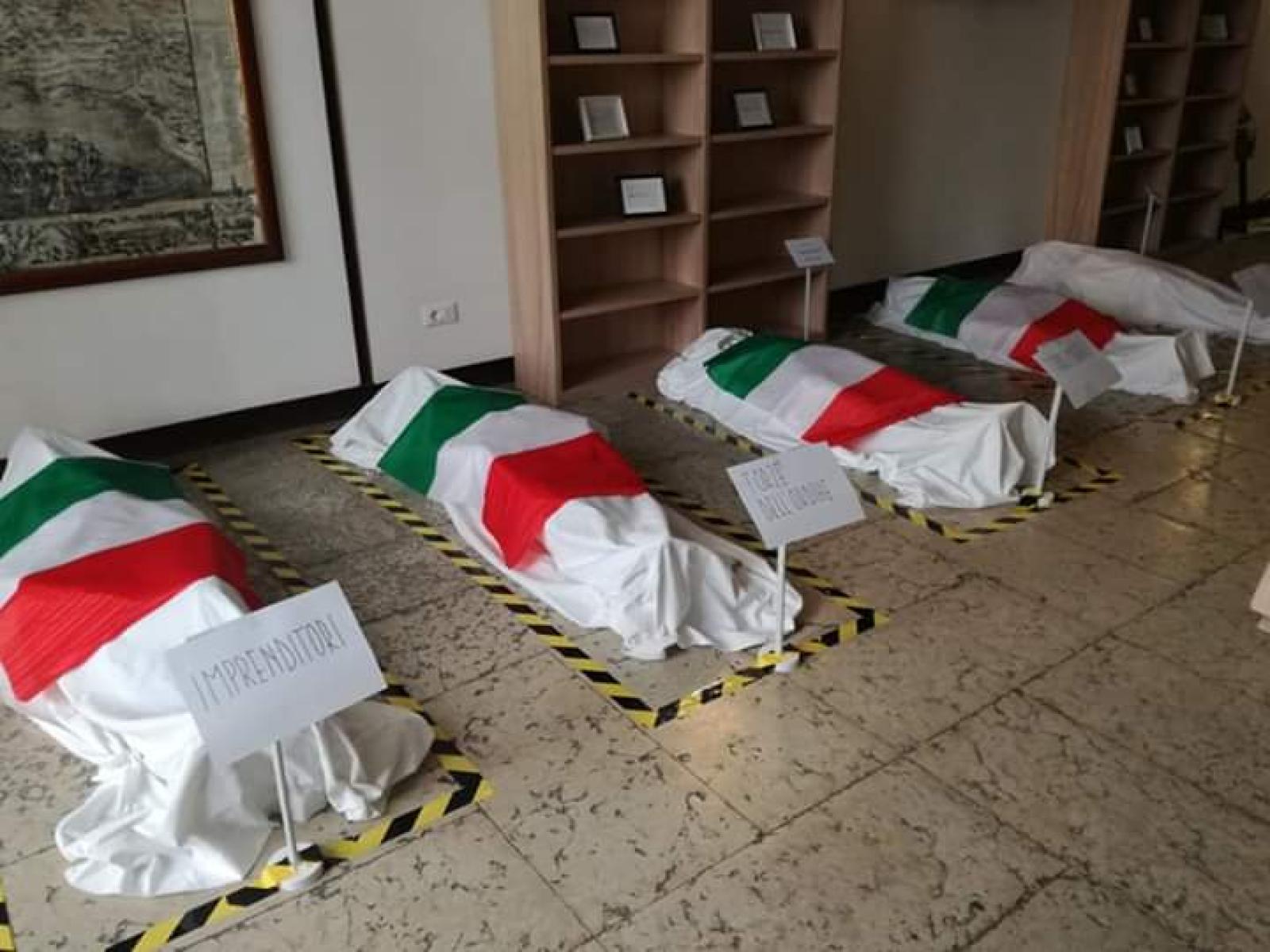 Bandiere tricolori sui "corpi" dei migranti