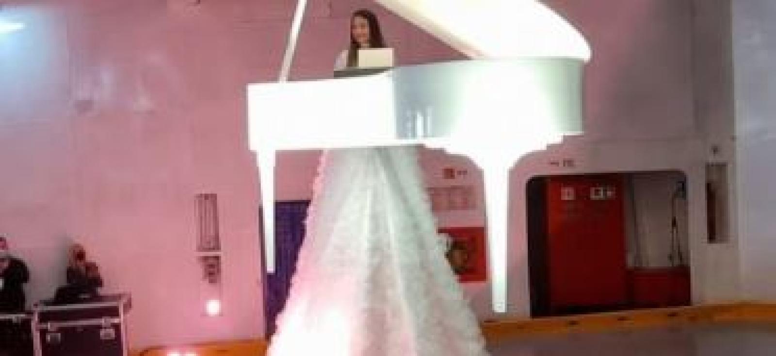 Sospesa sopra un traghetto, suona il pianoforte