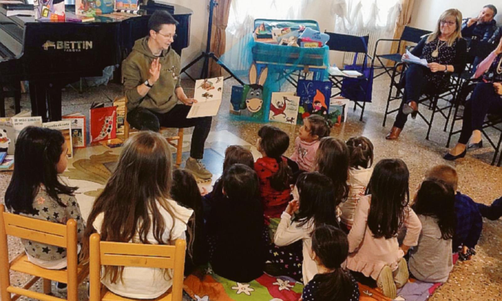 Bimbi in biblioteca coi libri in mano