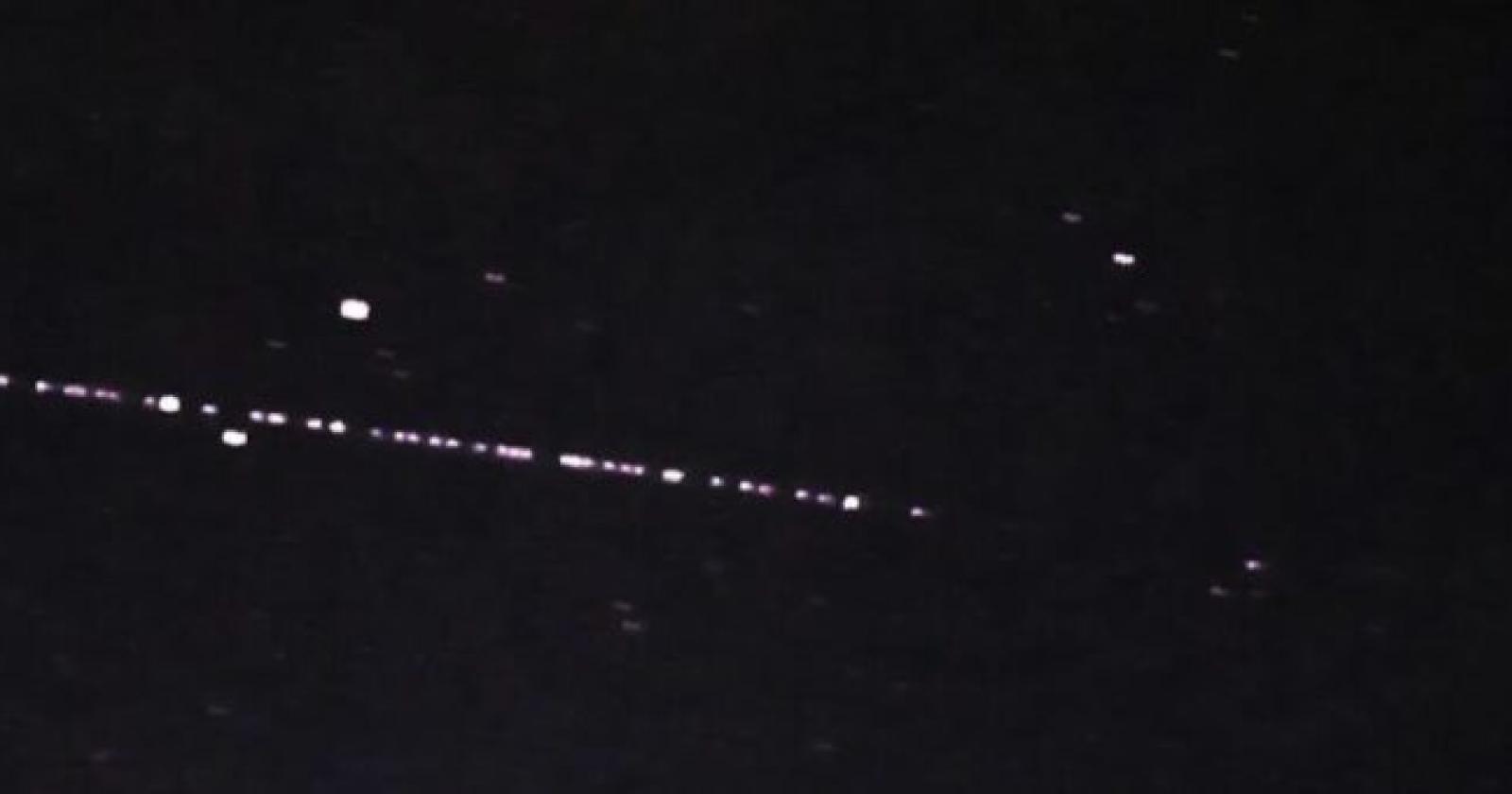 Luci in fila che si muovono nel cielo notturno