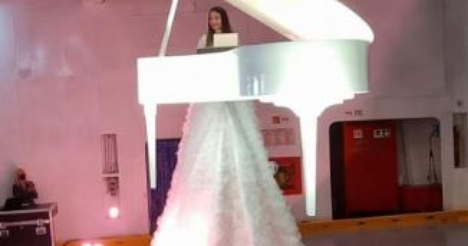 Sospesa sopra un traghetto, suona il pianoforte