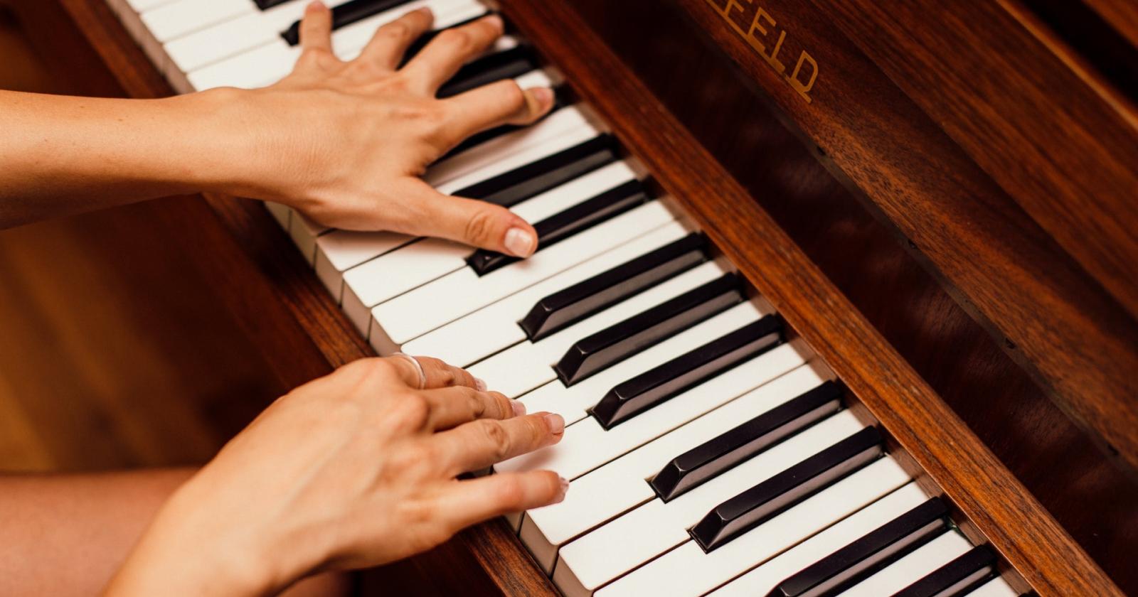 Sospesa sopra un traghetto, suona il pianoforte