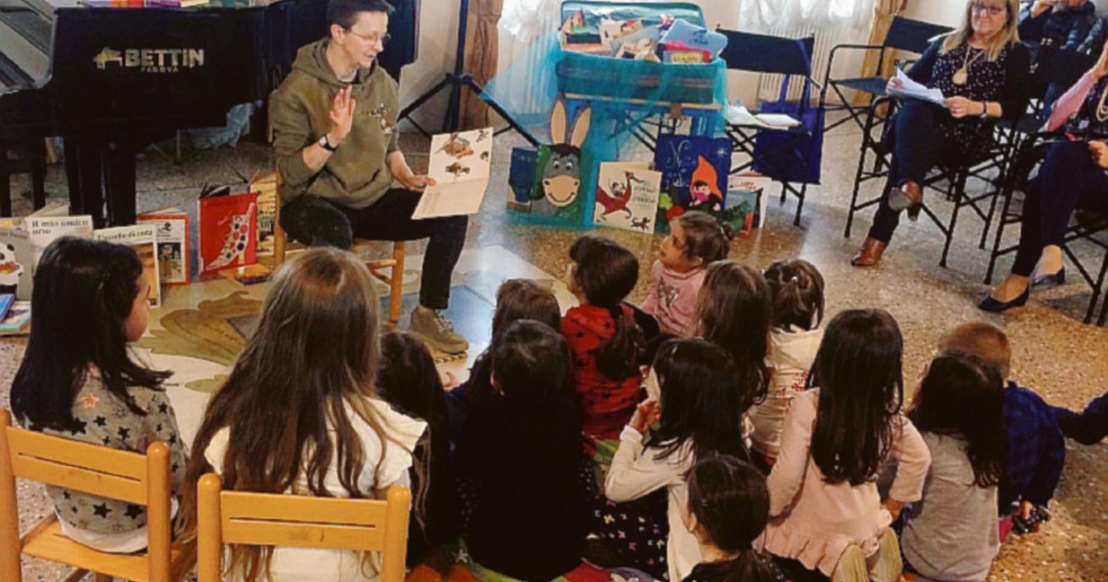 Bimbi in biblioteca coi libri in mano