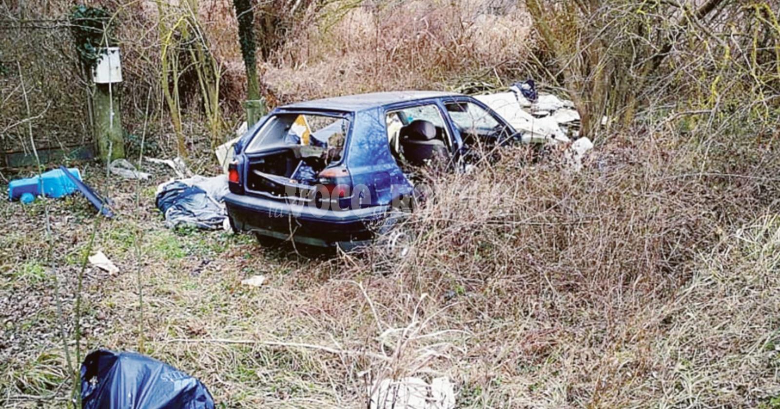 Un’auto abbandonata tra i rifiuti