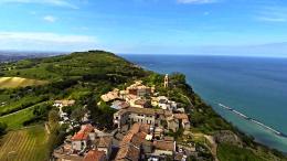 Di fonte mare limpido, alle spalle il borgo medievale