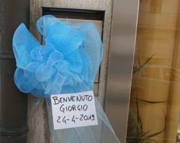 Fiocco azzurro sui negozi “Benvenuto, Giorgio”
