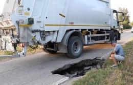 Una voragine in strada, e il camion dei rifiuti finisce... in buca