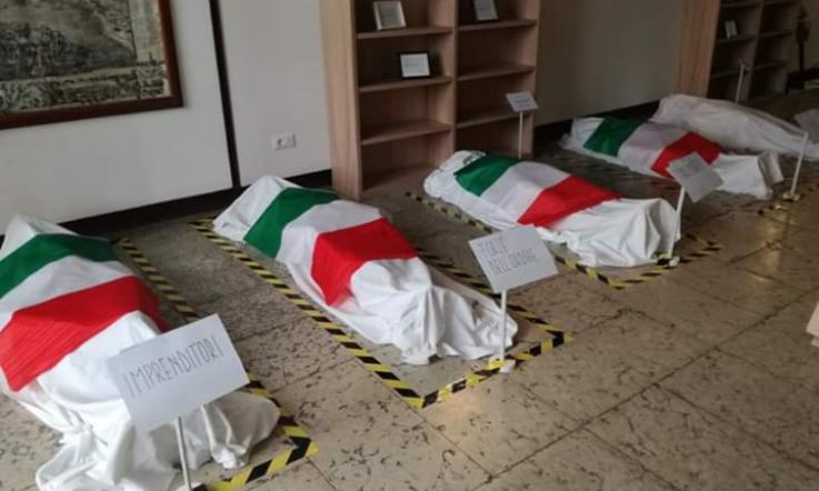 Bandiere tricolori sui "corpi" dei migranti